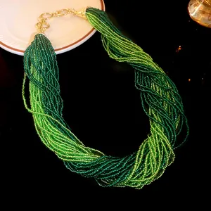 Exquisite macro detail of bohemian multi-strand green seed bead necklace with gold clasp