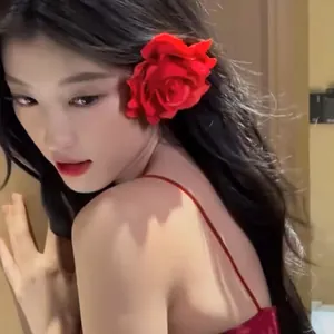 Detailed view of a romantic red rose hair clip worn by a model for a vintage look