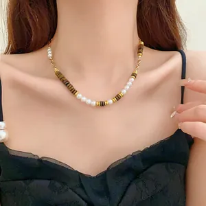 Elegant model wearing a vintage pearl and tiger eye stone necklace with gold accents