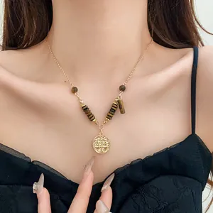 Close-up of retro gold necklace with tiger eye beads and Libra coin pendant