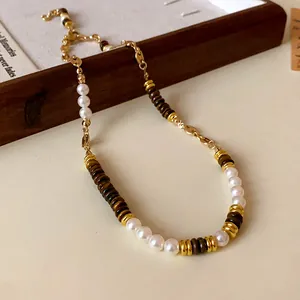 Macro view of vintage pearl and tiger eye stone necklace with gold-plated stainless steel