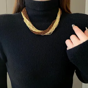 Detail shot of a bohemian multi-layer seed bead necklace worn over a black sweater