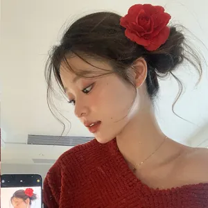 Detailed view of an elegant red rose flower hair clip worn by a model in spring style