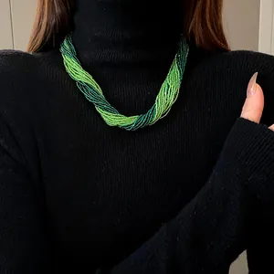 Detailed close-up of a Bohemian multi-layered green seed bead choker necklace on model