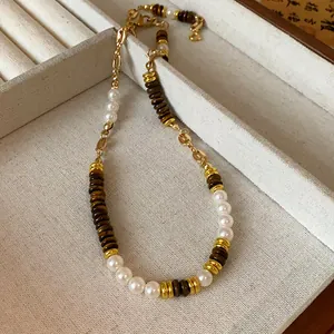 Close-up of vintage necklace with white pearls, tiger eye beads, and gold-tone stainless chain