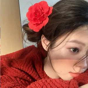 Close-up view of a vibrant red rose flower hair clip duckbill style worn by an Asian model