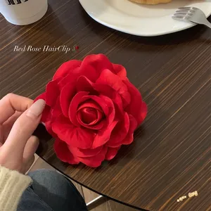 Detailed view of a large red rose flower hair clip for an elegant spring hairstyle