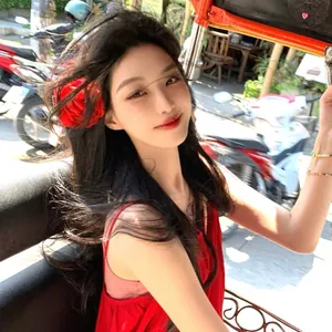 Close-up of a vibrant red rose flower hair clip worn by a model in a lifestyle setting