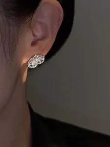 Detailed view of elegant zircon butterfly stud earring with sparkling stones on ear