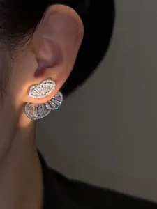 Detailed macro view of sparkling zircon butterfly jacket earrings worn on an ear