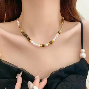 Close-up of vintage pearl and tiger eye bead necklace worn by a model