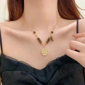 Detail view of vintage Maillard style tiger eye stone necklace with gold coin pendant