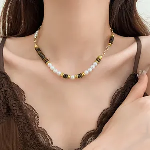 Close-up of a vintage pearl and tiger eye stone necklace worn on a model's neck