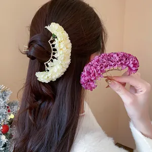 Detailed view of handmade fabric flower hair pins in cream and purple colors.