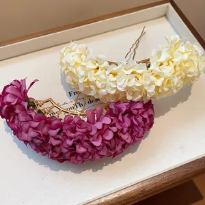 Detailed view of elegant cream and purple fabric flower hairpins in a display tray