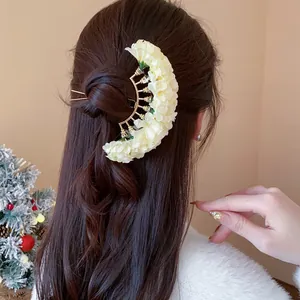 Close-up of an elegant cream fabric flower hair pin used for romantic hairstyles