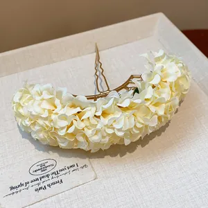 Detailed view of an elegant fabric flower hairpin with a sweet cream-colored arch design