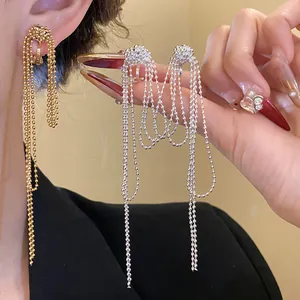 Detail of vintage 18k gold plated knotted tassel clip-on earrings in gold and silver.