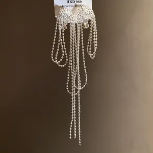Detailed macro shot of elegant silver long ball chain tassel clip-on earrings with retro style