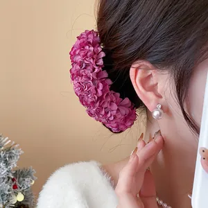Close-up detail of an elegant purple fabric floral hair clip accessory for women styling