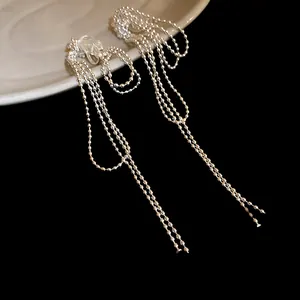Close-up of elegant 18k gold plated knotted beaded tassel ear clips in minimalist style