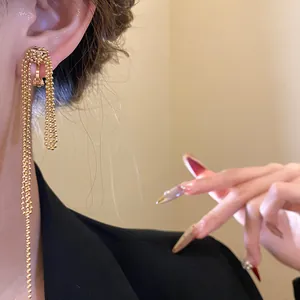 Close-up detail of 18k gold plated knot tassel clip-on earrings with metallic beads