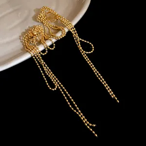 Close-up of 18k gold-plated knotted tassel clip-on earrings with beaded chains