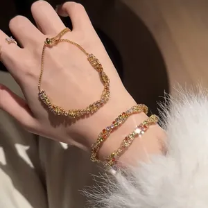 Vue détaillée de bracelets en zircon coloré torsadé scintillant au poignet avec manche