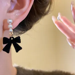 Close-up detail of an elegant French vintage earring featuring pearls and a black velvet bow