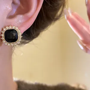 Close-up macro view of a vintage black stone stud earring with a sparkling rhinestone border