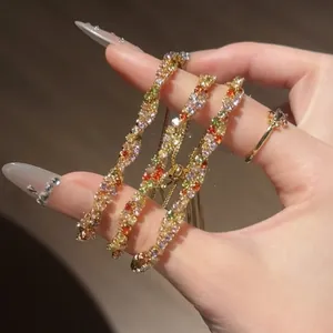 Détail d'un bracelet torsadé en zircon multicolore avec des pierres étincelantes.