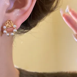 Close-up view of French retro camellia rose and pearl stud earring on model's ear.