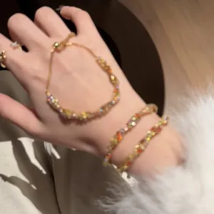 Détail en gros plan de bracelets torsadés en zircons colorés au poignet d'une femme