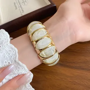 Close-up of a French style marbled white acrylic geometric stretch bracelet on wrist
