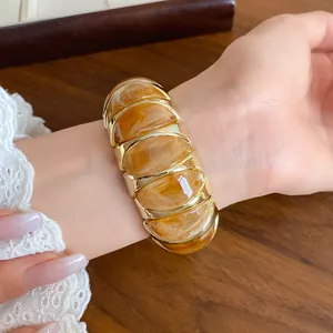 Close-up of a French amber acrylic marble effect elastic bracelet worn on a woman wrist