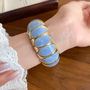 Detailed view of sky blue marbled acrylic geometric elastic bracelet with gold trim