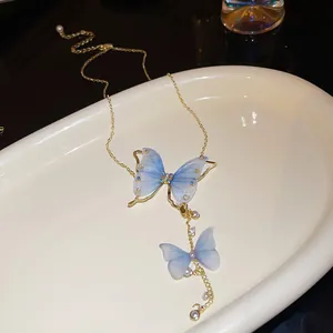 Dettaglio di una collana a farfalla blu con strass e perle sintetiche
