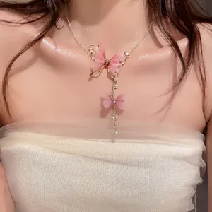 Dettagliata vista ravvicinata di un elegante collana con farfalla in tulle rosa e perle fini