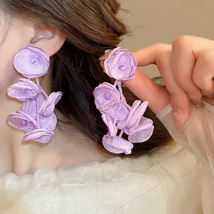 Vista dettagliata di eleganti orecchini a nappa con fiori in tessuto viola su modella