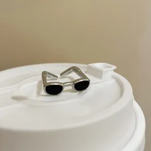 Anello aperto unico a forma di occhiali da sole argentati con smalto nero.