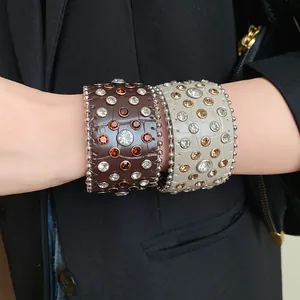 Primo piano di bracciali rigidi in pelle vintage con strass colorati e borchie