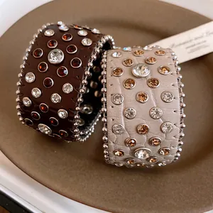 Vista dettagliata di bracciali rigidi in pelle retrò con strass scintillanti e borchie metalliche