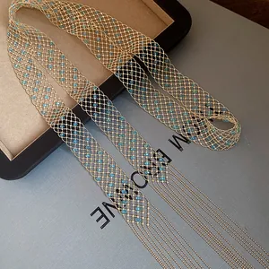 Dettaglio della collana a maglia dorata con perline di cristallo blu e lunghe nappe.