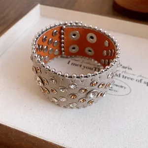 Primo piano di un bracciale in pelle vintage con strass e dettagli in rivetti argento