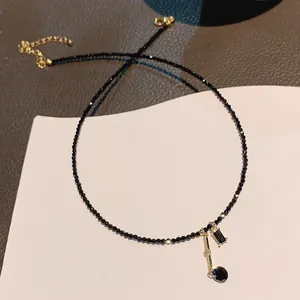 Elegant black beaded choker necklace with gold-plated musical note and black gemstone pendant