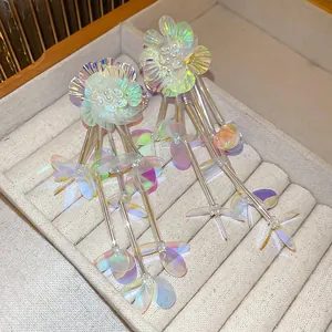 Primo piano di orecchini a nappa con fiori iridescenti in un vassoio per gioielli