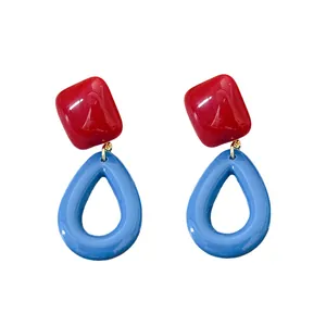 Retro-style bold resin drop earrings featuring red and blue geometric shapes on white background