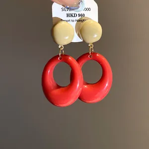 Vintage style resin oval drop earrings in vibrant red and cream finish detail view