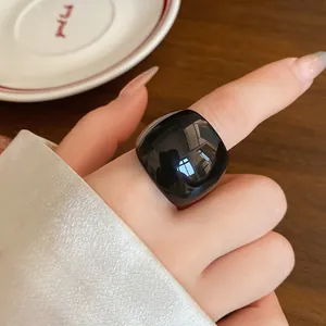 Macro di un anello in resina nera lucida che mostra la superficie liscia e curva
