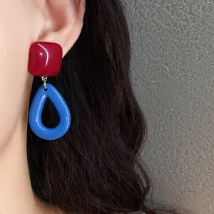 Detailed view of vintage resin drop earrings in vibrant red and blue dopamine colors